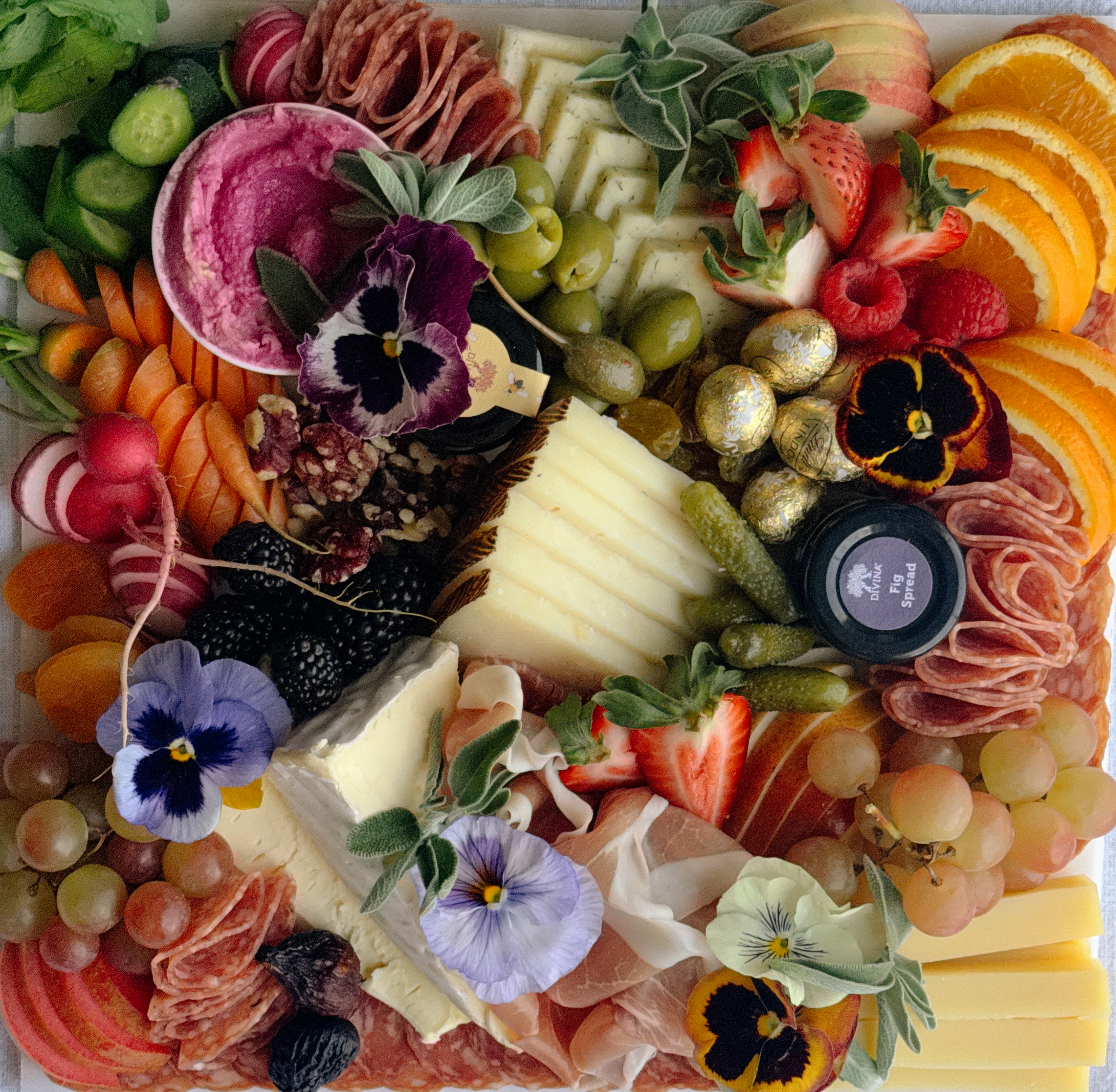 Outdoor charcuterie picnic setup with fruits and meats